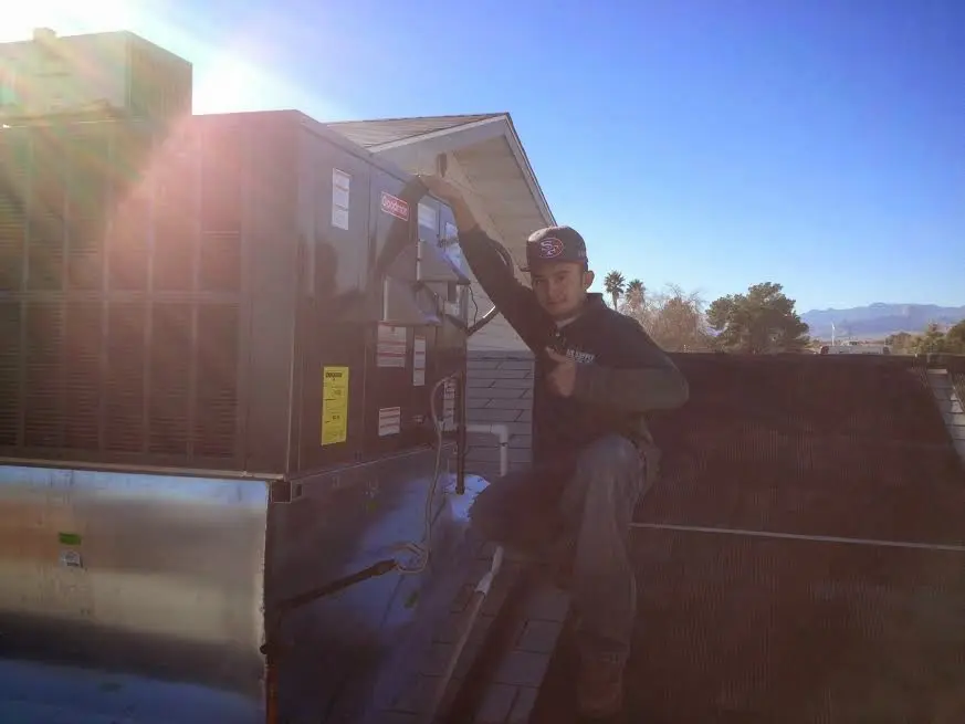 HVAC technician performing Air Duct Cleaning on a rooftop unit in Windsor